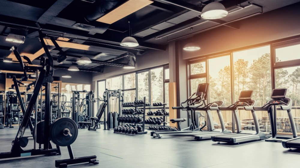 Modern gym with treadmills and weights, symbolizing healthy coping strategies for divorced fathers managing stress and grief