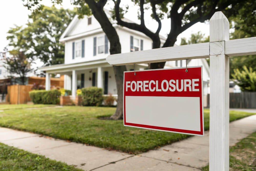 Foreclosure sign outside a home — the risk of losing housing during grief.